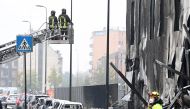 Fire fighters work at the scene where a small plane crashed into a building in San Donato Milanese, Italy, October 3, 2021. REUTERS/Flavio Lo Scalzo