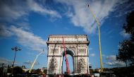 Rope access technicians work on the removal of the fully wrapped Arc de Triomphe monument, after it was wrapped for an art installation entitled 'L'Arc de Triomphe, Wrapped' conceived by the late artists Christo and Jeanne-Claude, on the Champs-Elysees av