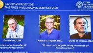 Photographs of the 2021 Nobel economics prize winners David Card, Joshua Angrist and Guido Imbens appear on a screen during the announcement of the award at a news conference at the Royal Swedish Academy of Sciences in Stockholm, Sweden, October 11, 2021.
