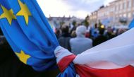 The flags of Poland and European Union are tied together during a rally in support of Poland's membership in the European Union after the country's Constitutional Tribunal ruled on the primacy of the constitution over EU law, undermining a key tenet of Eu