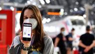 A woman shows her digital COVID-19 certificate at a train station in Milan, Italy, September 1, 2021. REUTERS/Flavio Lo Scalzo