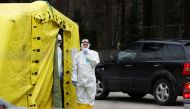 A health care worker wears protective suit as she waits for patients to be tested for coronavirus disease (COVID-19) next to a mobile laboratory in Riga, Latvia March 16, 2020. REUTERS/Ints Kalnins

