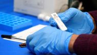 Health workers and volunteers handle lateral flow test samples and record results as students take coronavirus disease (COVID-19) tests in London, March 5, 2021. REUTERS/Toby Melville/File Photo