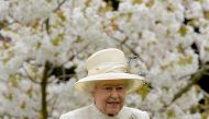 FILE PHOTO: Britain's Queen Elizabeth walks among spring blossom and flowers as she arrives to attend the unveiling of a statue in Windsor,southern England, March 31, 2014. REUTERS/Toby Melville/File Photo
