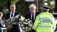 Britain's Labour Party leader Keir Starmer and Prime Minister Boris Johnson hold flowers as they arrive at the scene where British MP David Amess was stabbed to death during a meeting with constituents at the Belfairs Methodist Church, in Leigh-on-Sea, Br