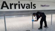 A worker sanitises a barrier at the International arrivals area of Terminal 5 in London's Heathrow Airport, Britain, August 2, 2021. REUTERS/Peter Nicholls