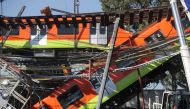 Workers move a train car from a site where an overpass for a metro partially collapsed with train cars on it at Olivos station in Mexico City, Mexico May 4, 2021. REUTERS/Henry Romero