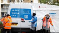 NHS workers are seen next to a coronavirus disease (COVID-19) mobile testing unit in Tower Hamlets, London, Britain, May 2, 2021. REUTERS/Peter Nicholls