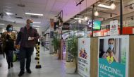 Shoppers, wearing protective face masks, walk past posters for a coronavirus disease (COVID-19) vaccination centre installed inside a supermarket in Brussels, Belgium, August 30, 2021. REUTERS/Bart Biesemans