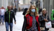 FILE PHOTO: People with and without protective masks walk on the street while shopping as the spread of coronavirus disease (COVID-19) continues in Amsterdam, Netherlands October 7, 2020. REUTERS/Eva Plevier/File Photo
