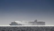 Salvage tug boats spray what appears to be water onto the container ship Zim Kingston after the crew were evacuated due to a fire on board, in Victoria, British Columbia, Canada October 24, 2021. REUTERS/Kevin Light
