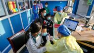A medical worker administers a dose of a coronavirus disease (COVID-19) vaccine to a child in Huzhou, Zhejiang province, China October 26, 2021. China Daily via Reuters