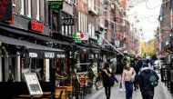 FILE PHOTO: People walk past restaurants and cafes in Amsterdam, Netherlands October 14 2020. REUTERS/Piroschka van de Wouw/File Photo
