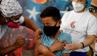 A public school student receives a dose of the Sinopharm vaccine against the coronavirus disease (COVID-19) as part of a vaccination campaign for adolescents, in Caracas, Venezuela October 27, 2021. REUTERS/Leonardo Fernandez Viloria/File Photo