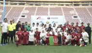 Players and officials pose for a photograph after the match at Khalifa International Stadium.