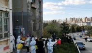 People line up for nucleic acid testing at a residential compound following local cases of the coronavirus disease (COVID-19) in Dalian, Liaoning province, China November 10, 2021. China Daily via REUTERS