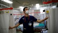 FILE PHOTO: St. Marianna University Yokohama Seibu Hospital department of emergency and critical care medicine doctor Hiroki Saito draws plastic curtain at emergency and critical care room inside the hospital where patients suffering from the coronavirus disease (COVID-19) are being treated in Yokohama, south of Tokyo, Japan May 25, 2021. Picture taken May 25, 2021. REUTERS/Issei Kato/File Photo
