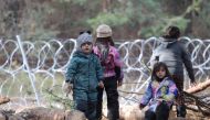 FILE PHOTO: Children gather near a barbed wire fence in a migrants' makeshift camp on the Belarusian-Polish border in the Grodno region, Belarus November 12, 2021. Ramil Nasibulin