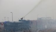 Polish law enforcement officers use a water cannon on migrants at Bruzgi - Kuznica checkpoint in the Grodno region, Belarus November 16, 2021. Leonid Scheglov/BelTA/Handout via Reuters 