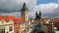 A clock showing the time at noon is pictured on a building, next to almost empty streets at Old Town Square during the coronavirus disease (COVID-19) outbreak, in Prague, Czech Republic, March 31, 2020. REUTERS/David W Cerny

