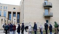 People stand in a queue for vaccination in front of a hospital as the spread of the coronavirus disease (COVID-19) continues, in Budapest, Hungary, November 22, 2021. REUTERS/Bernadett Szabo