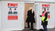 A woman enters a vaccination booth at a coronavirus disease (COVID-19) drive-in vaccination centre at Lanxess Arena in Cologne, Germany, November 23, 2021. REUTERS/Wolfgang Rattay