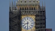 Workers stand on scaffolding underneath one of the clock faces on the Elizabeth Tower, more commonly known as Big Ben, as hands and dials are seen restored to the original Prussian blue colouring, whilst renovation works continue at the Houses of Parliament, London, Britain, September 6, 2021. REUTERS/Toby Melville/File Photo