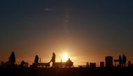 People watch the sun rise over the city's skyline from Primrose Hill in London, Britain, November 25, 2021. REUTERS/Hannah McKay