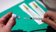 A medical worker prepares a dose of the 