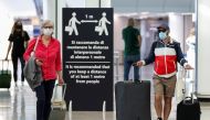 Passengers wearing protective face masks walk at Fiumicino Airport on the day EU governments agreed a 