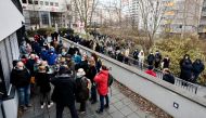 People wait outside of the practice of paediatrician Steffen Lueder during a weekend vaccination shift for over 400 people in Hohenschoenhausen, in Berlin, Germany, November 27, 2021. REUTERS/Hannibal Hanschke