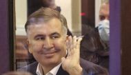 Georgian former President Mikheil Saakashvili, who was convicted in absentia of abuse of power during his presidency and arrested upon his return from exile, waves inside a defendant's dock during a court hearing in Tbilisi, Georgia, November 29, 2021. REUTERS/Irakli Gedenidze/Pool