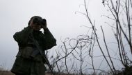A militant of the self-proclaimed Luhansk People's Republic looks through binoculars as he stands guard at fighting positions on the line of separation from the Ukrainian armed forces in the outskirts of Kirovsk in Luhansk Region, Ukraine December 1, 2021. REUTERS/Alexander Ermochenko