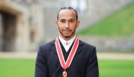 Lewis Hamilton poses for a photo after he was made a Knight Bachelor by Britain's Charles, Prince of Wales, during an investiture ceremony at Windsor Castle in Windsor, Britain, December 15, 2021. Andrew Matthews/Pool via REUTERS
