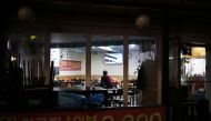 A restaurant owner watches a news report after closing his restaurant earlier, as part of tightened social distancing rules to contain a surge in coronavirus disease (COVID-19) infections, in Seoul, South Korea, December 20, 2021. REUTERS/Kim Hong-Ji