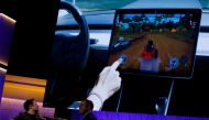 FILE PHOTO: Tesla CEO Elon Musk, at the E3 gaming convention in Los Angeles, California,U.S., June 13, 2019, watches a clip of a videogame in a Model 3 vehicle. REUTERS/Mike Blake/File Photo
