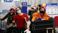 Travelers push their luggage past baggage claim inside the United Airlines terminal at Los Angeles International Airport (LAX) during the holiday season as the coronavirus disease (COVID-19) Omicron variant threatens to increase case numbers in Los Angeles, California, U.S. December 22, 2021. REUTERS/Bing Guan
