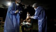 FILE PHOTO: A man is administered a vaccine for the coronavirus disease (COVID-19) at night during an outreach by healthcare workers who traveled by river into the Amazon rainforest to educate people from the indigenous Urarina community about the disease and offer medical care, in San Marcos, Peru October 11, 2021. Picture taken October 11, 2021. REUTERS/Sebastian Castaneda/File Photo
