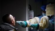 A man gets a nucleic acid test at a street booth as the coronavirus disease (COVID-19) outbreak continues in Beijing, China, January 12, 2022. REUTERS/Thomas Peter
 