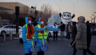 Volunteers show the way to an Olympic parking lot outside the closed loop 