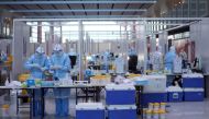 Staff members wearing personal protective equipment (PPE) designed to prevent the spread of the coronavirus disease (COVID-19), work at a COVID-19 testing site at Beijing Capital International Airport ahead of the Beijing 2022 Winter Olympics in Beijing, China, January 31, 2022.REUTERS/Hannah McKay