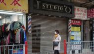 A pedestrian walks past a closed hair salon at a shopping mall, following the coronavirus disease (COVID-19) outbreak, in Hong Kong, China February 10, 2022. REUTERS/Lam Yik