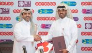 Sheikh Nasser bin Hamad bin Nasser Al Thani, Chief Commercial Officer at Ooredoo, and Tariq Zainal, Qatar Tennis, Squash and Badminton Federation's General Secretary, exchange documents during the sponsorship signing ceremony.