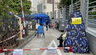 FILE PHOTO: A security guard wearing a face mask and face shield sits at an area outside a hospital, following the coronavirus disease (COVID-19) outbreak in Hong Kong, China February 16, 2022. REUTERS/Aleksander Solum/File Photo
