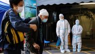A patient and her relative wearing personal protective equipment (PPE) wait outside the Accident and Emergency (A&E) department, following the coronavirus disease (COVID-19) outbreak, in Hong Kong, China March 4, 2022. REUTERS/Tyrone Siu


