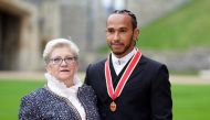 FILE PHOTO: Lewis Hamilton poses with his mother Carmen Lockhart for a photo after he was made a Knight Bachelor by Britain's Charles, Prince of Wales, during an investiture ceremony at Windsor Castle in Windsor, Britain, December 15, 2021. Andrew Matthews/Pool via REUTERS/File Photo
