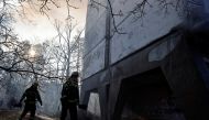 Firefighters walk as they help to put out a fire in a residential apartment building after it was hit by shelling as Russia's invasion of Ukraine continues, in Kyiv, Ukraine, March 15, 2022. REUTERS/Thomas Peter