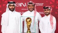 beIN Media Group employees pose for a photograph with the FIFA World Cup trophy.