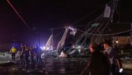 People walk past damaged infrastructure after a tornado struck in the Arabi neighborhood, St. Bernard Parish, New Orleans, Louisiana March 22, 2022. REUTERS/Kathleen Flynn