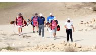 Players and their caddies walk at the Doha Golf Club during the opening round of Commercial Bank Qatar Masters, yesterday.

